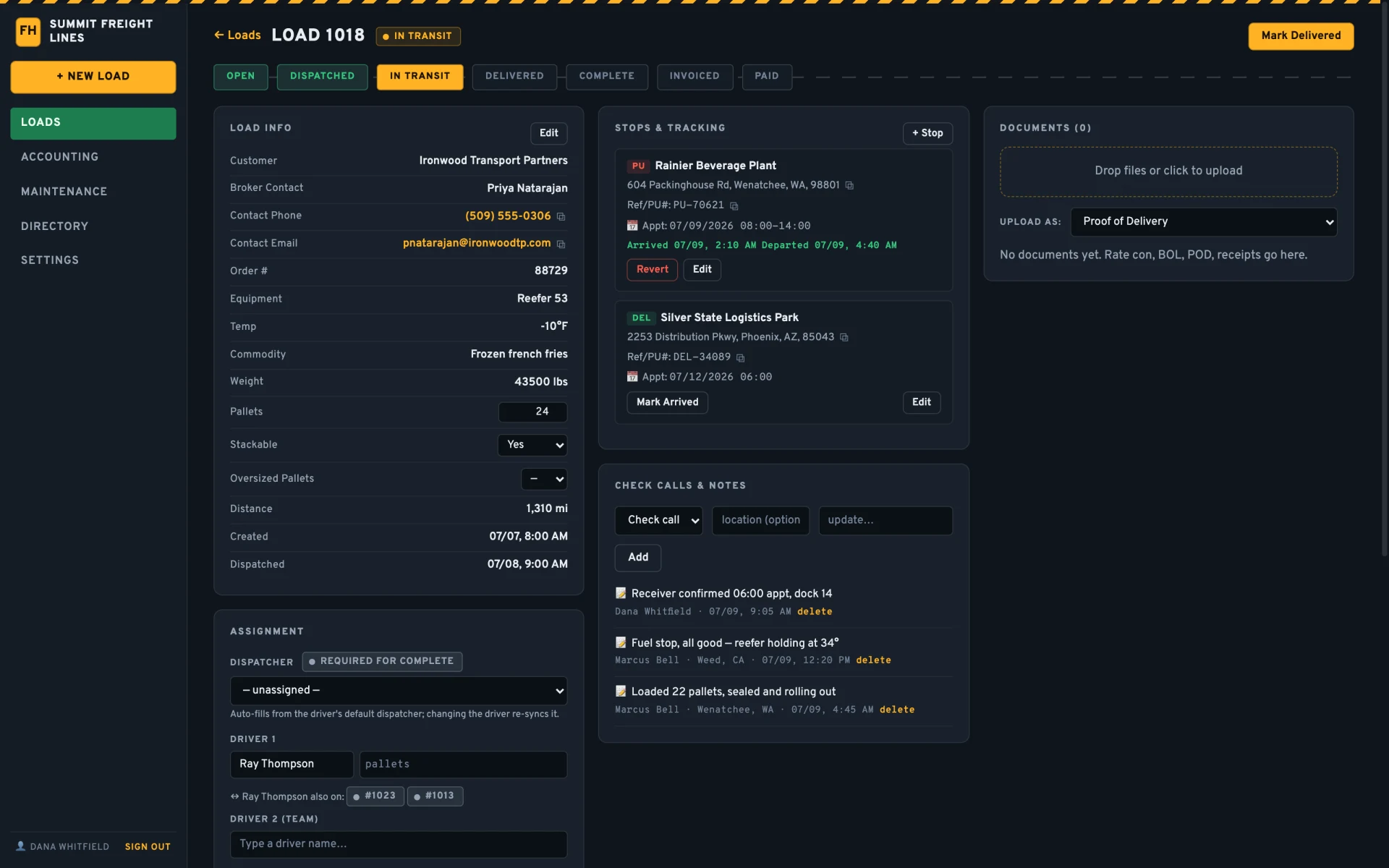 A load page in transit: load info, stops with arrival and departure times, documents panel, check calls, and driver assignment.
